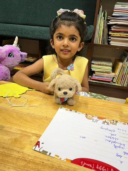 Another child poses with her adorable toy puppy at the craft table. It's wonderful to see the bond between the children and their special friends during our events.