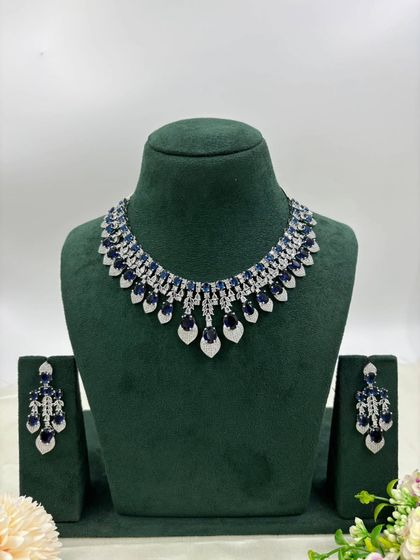 The leaf-shaped necklace with blue stones.