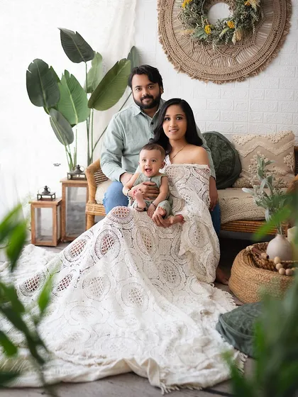 A beautiful family portrait with a natural, earthy feel, thanks to the boho decor and green plants.