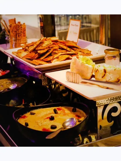 A buffet spread featuring a variety of Indian and fusion dishes, including paneer shawarma and assorted breads, showcasing the breadth of my menu.