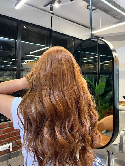 The client admiring her new medium absolute brown color in the mirror. The shine and health of the hair are evident.
