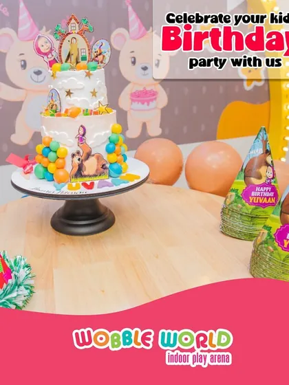 A beautifully decorated table set for a Masha and the Bear themed birthday party, complete with a detailed cake and party hats.