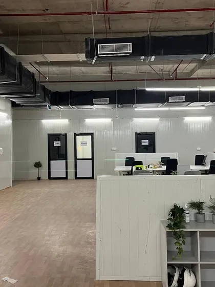 This image shows the raw, industrial aesthetic of the space before full furnishing, highlighting the exposed ceiling with HVAC ducting and the insulated PUF panel walls we supplied and installed.