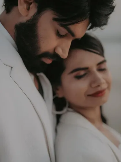 An intimate, soft-focus close-up. This dreamy shot focuses on the tender connection between the couple, with the gentle beach light adding to the romantic mood.