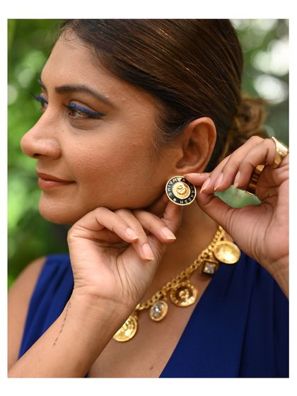 A guest at our studio event tries on a pair of bold, modern earrings, holding a piece of jade for color comparison. This is part of the collaborative process of finding the perfect match.