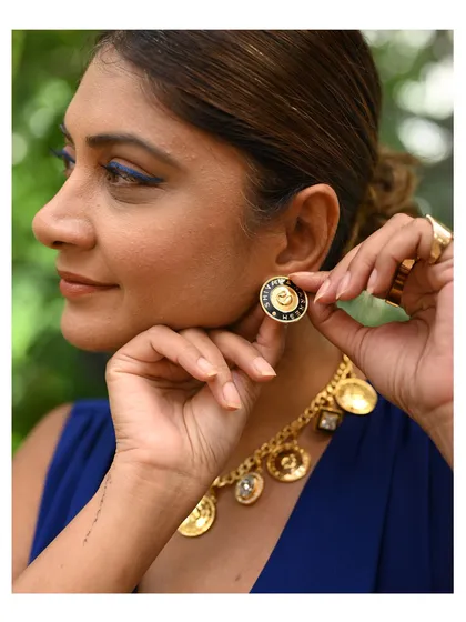 A guest at our studio event tries on a pair of bold, modern earrings, holding a piece of jade for color comparison. This is part of the collaborative process of finding the perfect match.