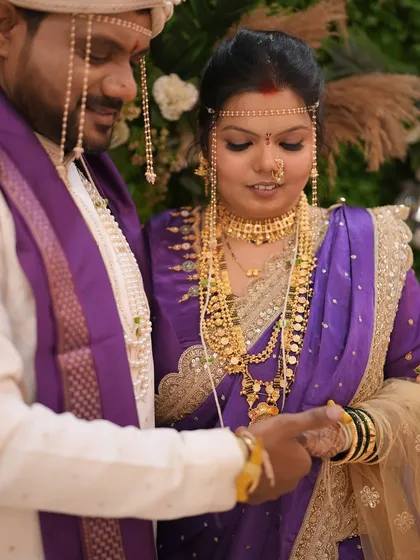 A close-up of the wedding rituals, showcasing the bride's intricate gold jewellery and traditional 'mundavalya'.