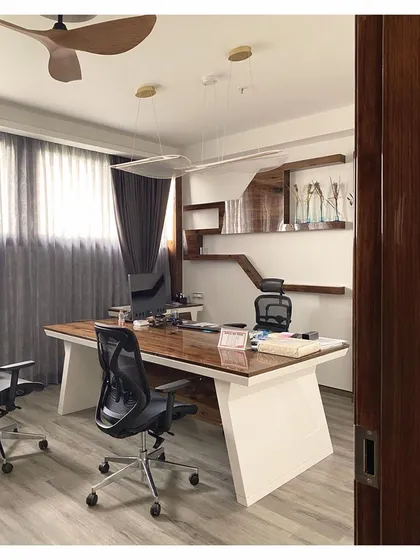 This angle reveals the ergonomic considerations and material choices, with comfortable office chairs and heavy curtains for privacy and light control, ensuring a productive work environment.
