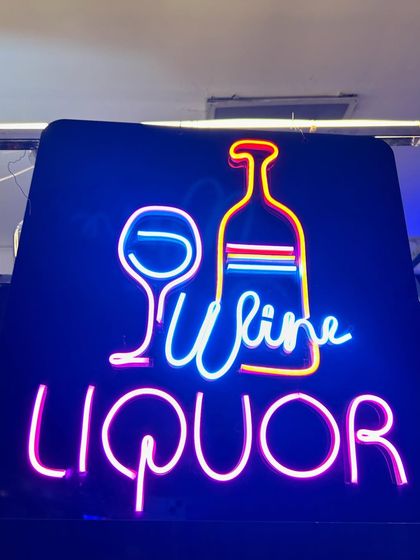 A bright and colorful 'Wine & Liquor' neon sign, perfect for guiding guests to their drink of choice.
