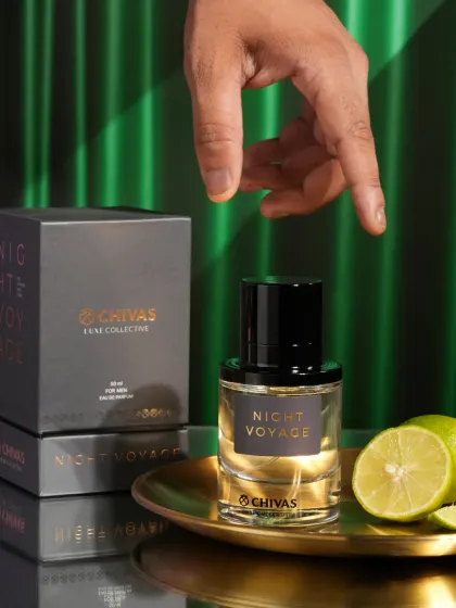 A luxury perfume shot with a hand model, using a rich green background and golden plate. The composition and color palette create a feeling of elegance and prestige.