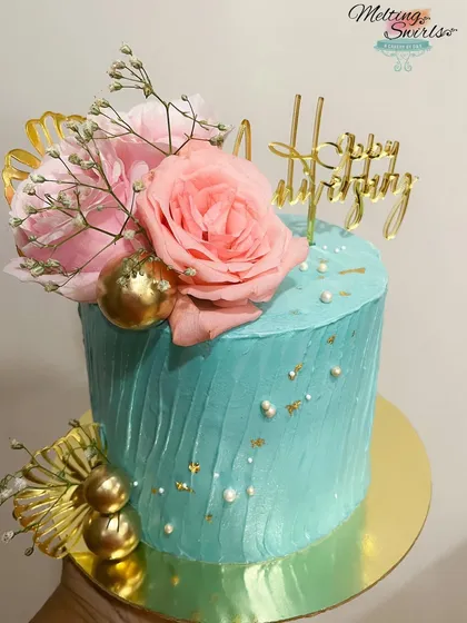 Another angle of the turquoise and pink floral buttercream cake, showing off the vibrant colors and elegant design.