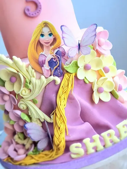 A detailed close-up of the Rapunzel cake, showing the combination of a 2D edible image and 3D fondant work.
