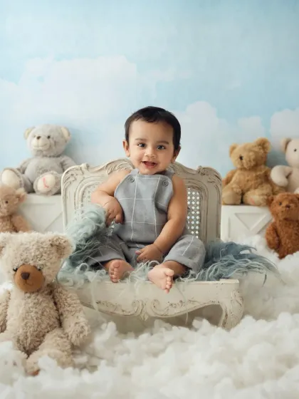 A full view of the cloud and teddy bear setup, with a happy baby boy as the star of the show.