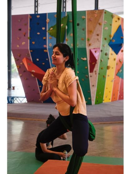 A student finds a moment of peace and balance in the aerial hammock, demonstrating the meditative aspect of our Vayu Yoga classes.