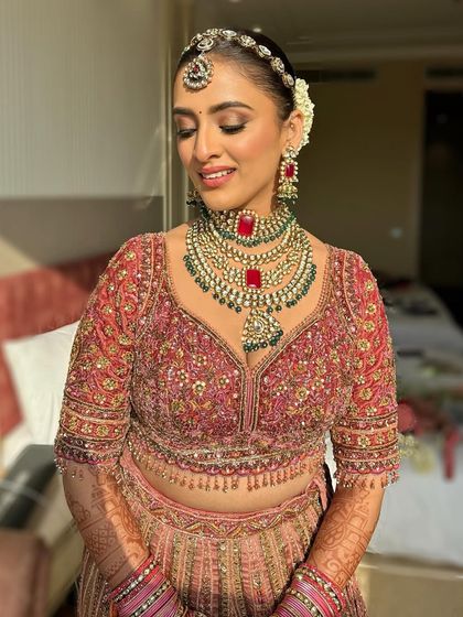 A close-up of the bride's glowing face, showcasing the sophisticated glam that complements her pink bridal attire.