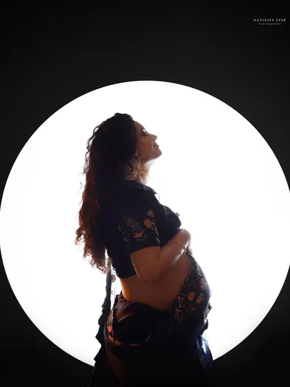 A beautiful silhouette of a mother-to-be in a saree. This shot combines traditional attire with a modern, artistic lighting technique.