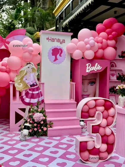 Welcome to the Barbie era! This all-pink 3rd birthday party features a life-sized Barbie box, custom signage, and a balloon-filled marquee number, creating a playful and immersive world for the celebration.