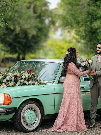 Ameera and Richard sharing a moment before their reception. The floral-adorned vintage car adds a touch of classic elegance to their celebration.