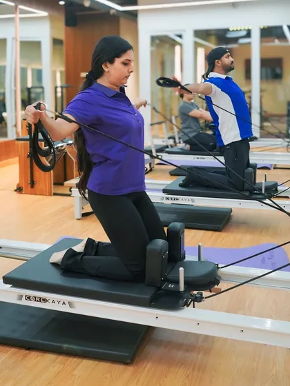 In this kneeling exercise, clients use the reformer straps to work their back and arm muscles. I focus on ensuring proper alignment to maximize benefits and prevent injury.