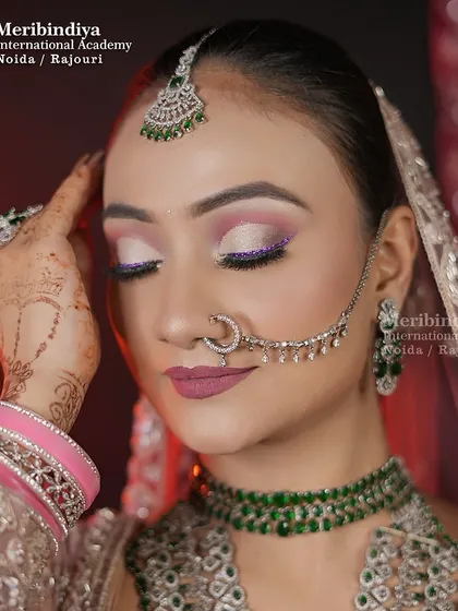 This look features soft, shimmery eye makeup with a pop of purple glitter, paired with a matte mauve lip. It's a perfect example of a modern reception look.
