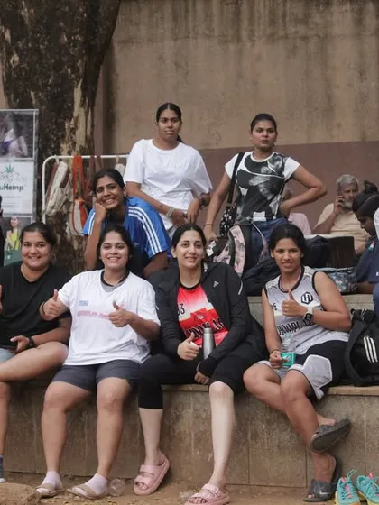 The women's team relaxing on the sidelines, giving thumbs up and peace signs. The vibe is always positive.