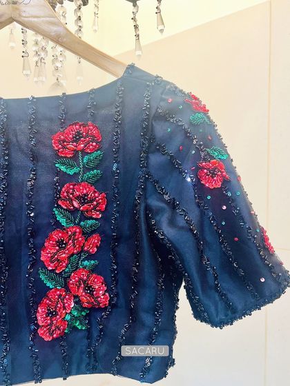 The studio shot of the black blouse with vibrant red floral embroidery, perfect for a cocktail saree.