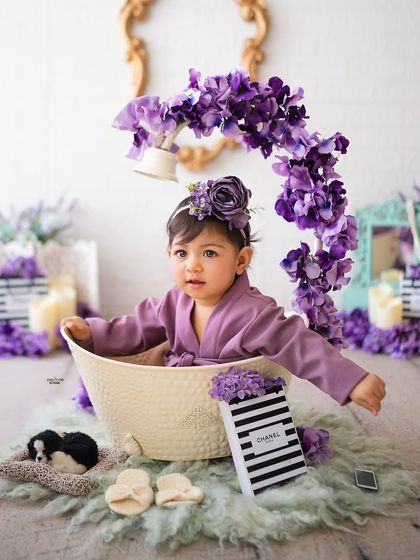 Enjoying a luxurious bath in a tub filled with purple flowers. A very creative and fun shot.