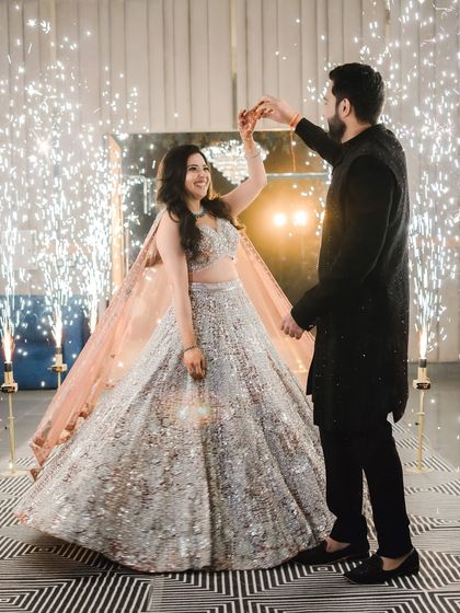The couple shares a dance at their sangeet, surrounded by the magical glow of cold pyro. This shot is full of energy, romance, and celebration.