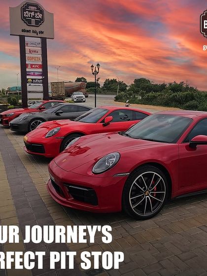 A lineup of red Porsches perfectly arranged in our parking lot against a beautiful sunset sky, creating a picture-perfect moment for any car lover.