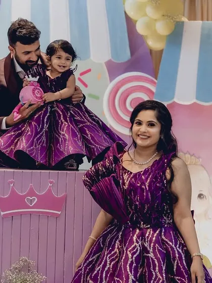 A sweet family moment at the Candyland party, with the parents and birthday girl dressed in matching magnificent purple outfits.