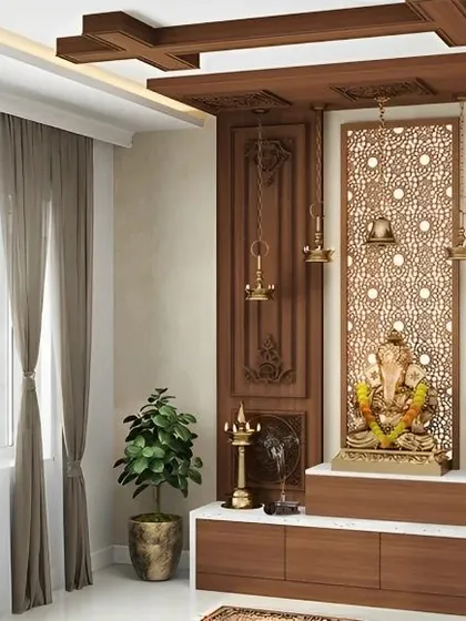 A visualization of a serene and traditional Pooja room. We design dedicated spiritual corners that blend seamlessly with your home's modern aesthetic, incorporating elements like intricate jali panels, warm wood tones, and elegant brass lamps.