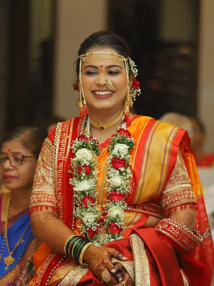 A joyful, candid shot of the bride during the ceremony. Her smile lights up the frame, and her makeup looks fresh and beautiful.