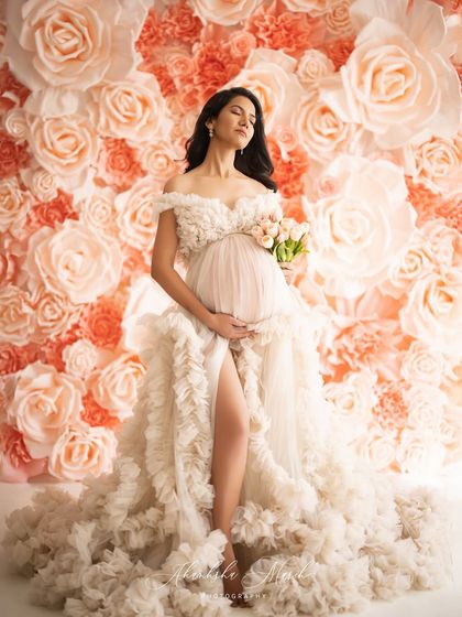 A vision of grace against a wall of blooming flowers. This textured gown and floral backdrop come together to create a portrait that is both romantic and deeply elegant.