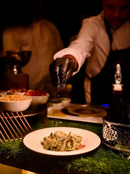 A final sprinkle of seasoning is added to a freshly made pasta dish, a small touch that makes a big difference in flavour.
