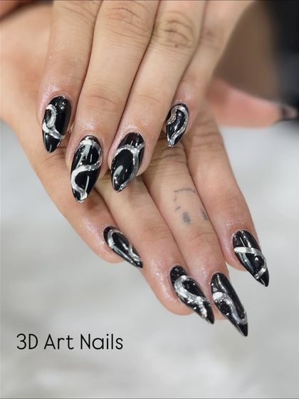 Bold and dramatic 3D art. I used a silver metallic gel to create these raised, swirling patterns over a glossy black base on long stiletto nails.