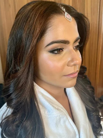 A beautiful profile of the bride in her robe, with her makeup and hair almost complete. The anticipation and excitement are building.