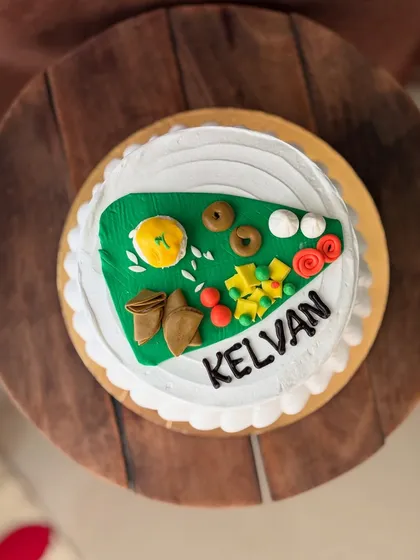 A top-down view of the custom 'Kelvan' cake, showing the detailed, edible food platter.