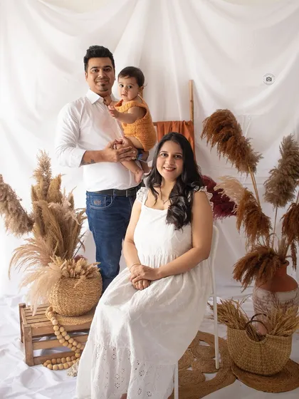 A beautiful family portrait with a relaxed, boho vibe. The coordinated white and neutral outfits work perfectly with the pampas grass and natural textures.