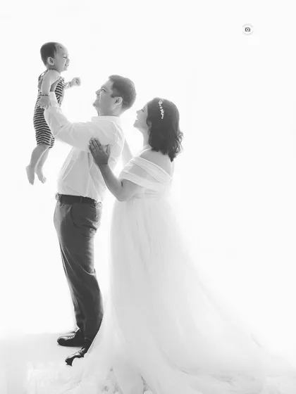 A joyful family moment captured in timeless black and white. This high-key photo has an angelic feel, celebrating the love between parents and their child.