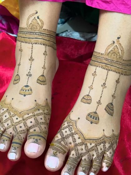 A simple and elegant payal-style mehandi for the feet. The design features hanging jhumkis and a light pattern on the toes, perfect for any occasion.