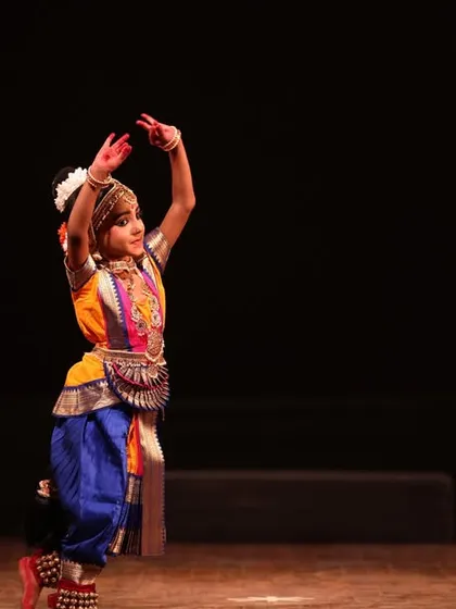 Two of my younger students sharing the stage at the Sadhana festival, one in a dynamic pose and the other observing, showing the supportive learning environment we foster.