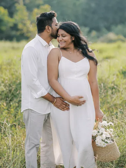 Another beautiful moment from their outdoor session, with a basket of fresh flowers. The partner's kiss on her forehead is a gesture of pure affection and tenderness.