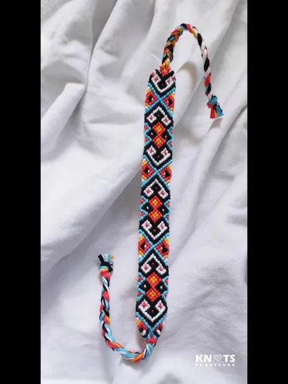 A full view of the geometric friendship bracelet, showing the beautiful, repeating pattern and braided ties.