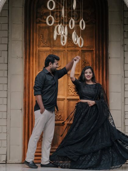 A couple shares a dance in front of a grand doorway, with modern ring lights adding a unique, glowing effect.