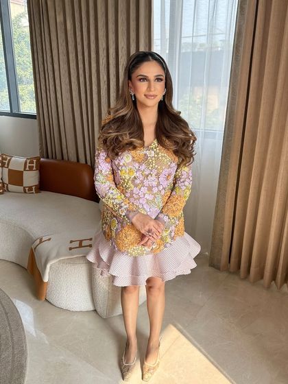 The full look, showing how the sleek half-ponytail complements the client's fashionable and floral outfit.