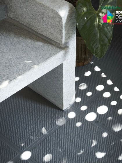 The dappled light filtering through a perforated ceiling onto the floor of the '10x10 Residence'. This detail shows how we use architectural elements to create dynamic, ever-changing patterns of light.