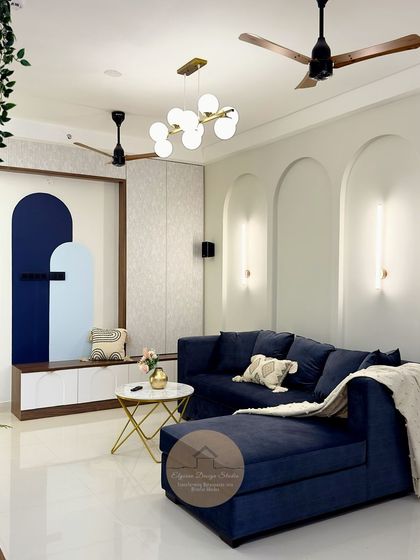 A beautiful living room at Candeur Signature, Bangalore. We used arches and a bold blue sofa to create a modern yet timeless space. The custom TV unit features a unique painted design, adding an artistic touch.