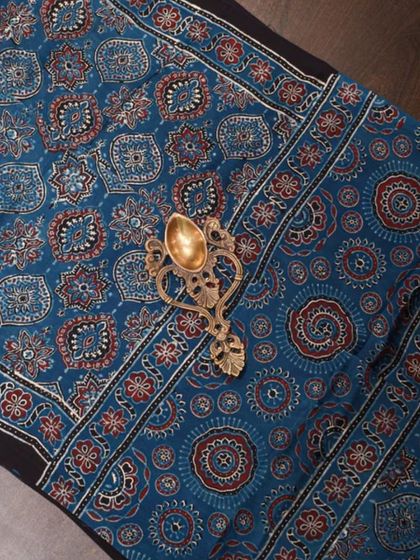 A vibrant blue and red Ajrakh printed fabric, showcasing the rich colors and complex patterns that make this craft so special.