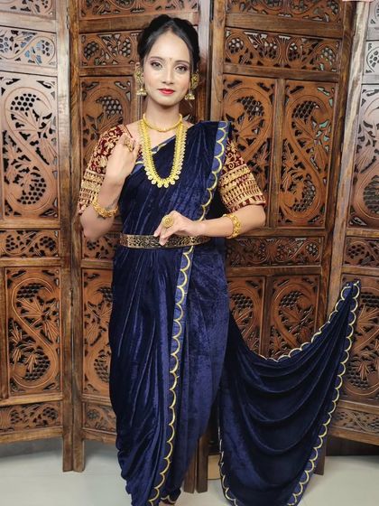 A stunning dhoti drape using a deep blue velvet fabric. This modern interpretation is perfect for a cocktail party or a reception, offering a unique and regal silhouette.