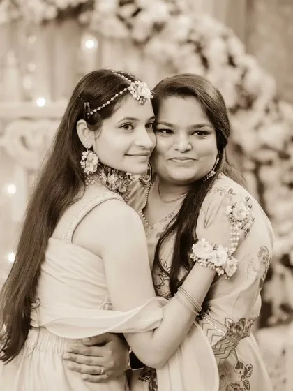 A lovely portrait of the bride with her sister or a close friend during the Haldi. Their happy smiles and close hug capture a moment of shared joy.
